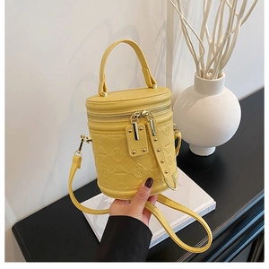 Detail of yellow bucket bag featuring diamond lattice embossing and bear pattern texture