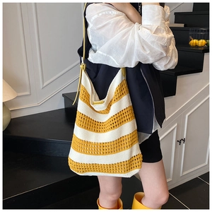 Detail of hand-woven striped tote bag with yellow leather strap and crochet texture