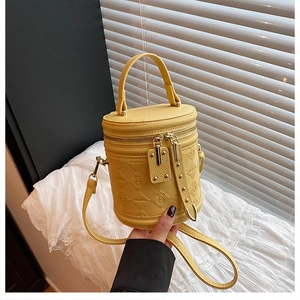 Detail of yellow bucket bag featuring bear embossing and lychee texture material