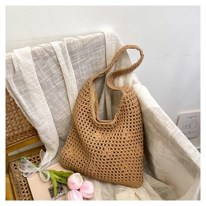 Detail of hand-woven hollow bucket bag on rattan chair with aesthetic floral background
