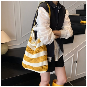 Detailed knit texture of a yellow and white striped hollow out tote bag with leather strap