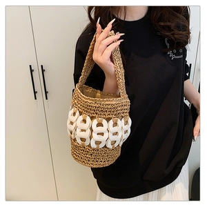 Detail of handmade woven bucket bag with white acrylic rings for beach vacation style