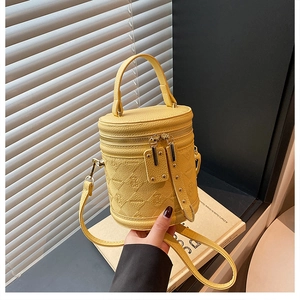 Detail of yellow bucket bag with teddy bear embossing and lychee pattern texture