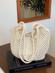 Large beige woven crochet tote bag with tassel charm for bohemian beach vacations