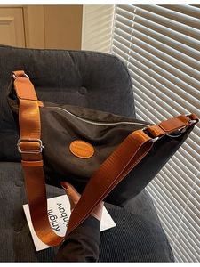 Minimalist black oxford fabric dumpling bag with brown wide strap and fashion leather tag