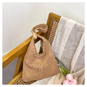 Close-up of handmade hollow crochet bucket bag with intricate woven net texture on wood