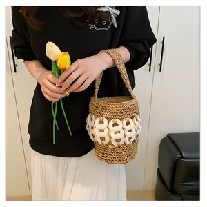 Detail of hand-woven straw bucket bag featuring white acrylic chain link accents