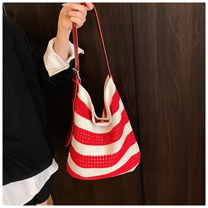 Detail of red and white striped crochet tote bag with red leather strap and knitted texture