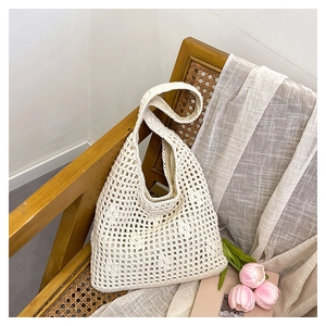 Detail of hollow woven bucket bag featuring cream mesh texture and cotton fabric lining