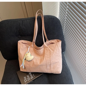 Close-up of pink crinkled nylon tote bag texture with plush moon charm detail