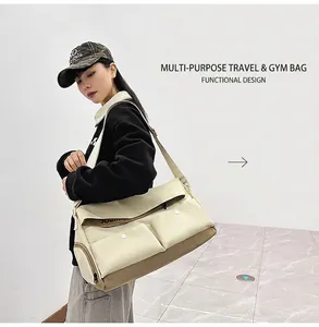Vue détaillée du grand sac bandoulière utilitaire avec deux poches avant boutonnées