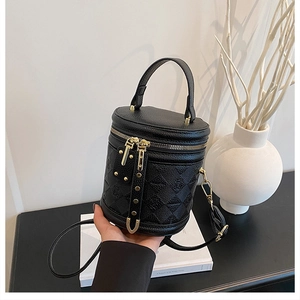 Close-up of black bucket bag with quilted rhombus pattern and gold metallic zipper details