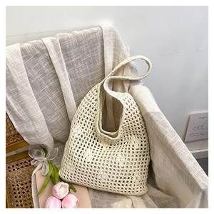 Detailed close-up of handmade hollow knit tote bag with 3D crochet flowers in cream white