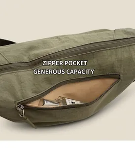 Detail view of the army green nylon shoulder bag featuring a side zipper pocket for storage