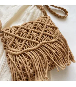 Detail of straw woven bag featuring diamond mesh texture and long tassels on cream fabric