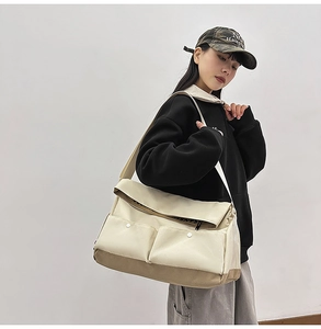 Détails d'un grand sac bandoulière en toile avec poches contrastées et large sangle