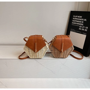 Detail of hexagon straw crossbody bags with brown leather flaps and gold metal bars