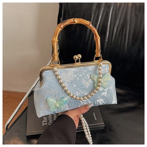 Detail of light blue jacquard shell bag with bamboo handle and pearl chain strap