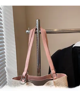 Detail of comfortable pink faux leather shoulder strap with silver metal ring and straw texture