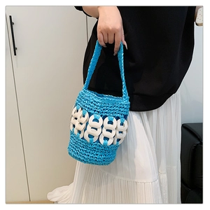Detail of blue hand-woven bucket bag with white decorative chain links on the texture