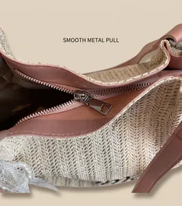 Detail of straw tote bag featuring pink leather trim, silver zipper, and lace pearl charm