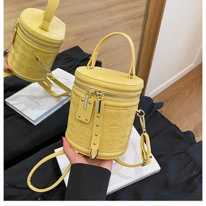 Detail of yellow bucket bag with bear embossed pattern and litchi grain texture