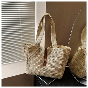 Détail du sac cabas en paille tissé à la main avec boucle en cuir brun et boucle dorée