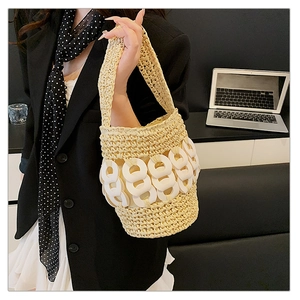 Detailed macro view of handmade woven straw bucket bag with white ring accents