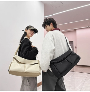Vue détaillée du grand sac bandoulière avec deux poches avant à pression pour voyage