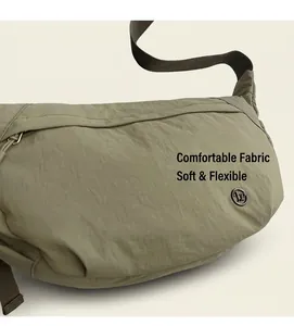 Detail of olive green nylon crossbody bag with adjustable strap and metallic logo