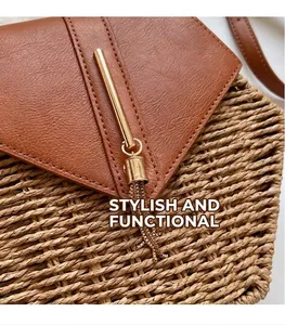 Detail of straw woven beach bag with brown lychee leather cover and gold tassel hardware