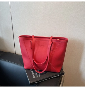 Close-up of red pebbled leather tote bag featuring debossed Fashion & Bag text detail