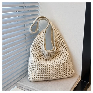Detail of hollow crochet bucket bag showing 3D floral accents and woven mesh texture