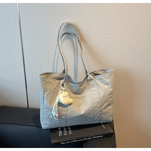 Detailed close-up of a large grey tote bag with TaoCaiFu embroidery and cloud charm