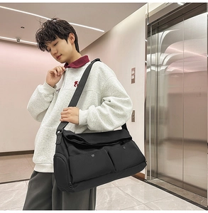 Vue détaillée d'un grand sac bandoulière en nylon noir avec plusieurs poches utilitaires