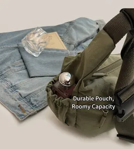 Detail view of military green nylon crossbody bag showing side drawstring storage pocket