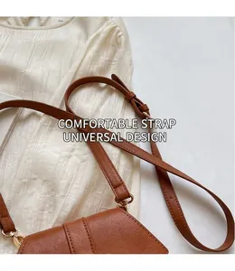 Detail of adjustable caramel leather strap with gold buckle on a crossbody bucket bag