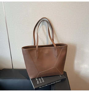 Detailed macro view of the brown leather tote bag with FASHION & BAGS lettering