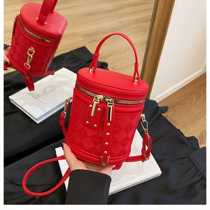 Detail of red bucket bag featuring pebble leather and embossed checkerboard pattern