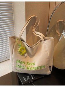 Canvas tote bag in beige with green embroidery and flower pendant for daily use