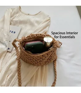 Detail shot of open straw crossbody bag interior showing phone, wallet and cosmetics capacity