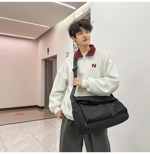 Vue détaillée d'un grand sac bandoulière noir en nylon avec sangle réglable sur un mannequin