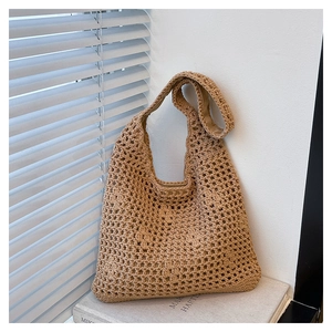 Detail of hollow crochet texture on khaki woven shoulder bag with wide strap