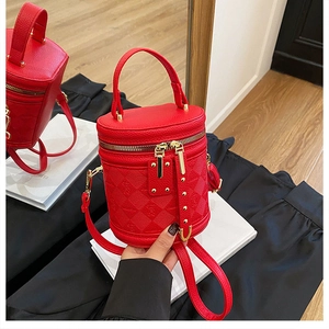 Detail of red bucket bag showing pebbled leather texture and bear pattern embossing