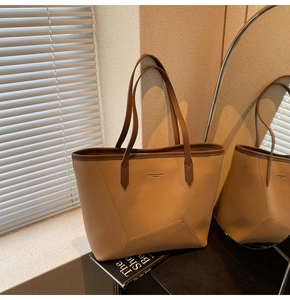 Detail shot of khaki tote bag featuring premium lychee texture and brown contrast straps