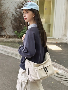 Large capacity off-white canvas messenger bag with dual front pockets and adjustable strap