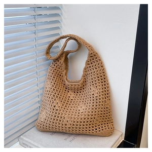 Detail of khaki crochet bucket bag showing intricate hollow weave texture and strap