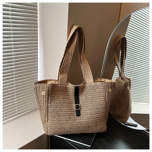 Détail du tissage fait main et de la boucle en cuir noir sur ce grand sac en paille