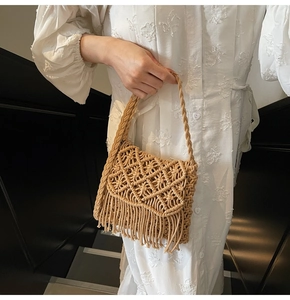 Détail du sac bandoulière en paille tressée avec longues franges et motif bohème