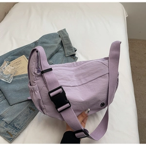 Detailed view of light purple nylon crossbody bag with wide strap and plastic buckle closure